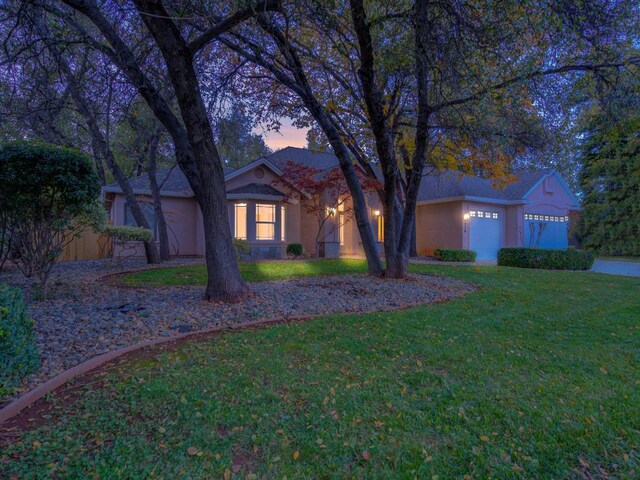 ranch-style house featuring a yard and a garage