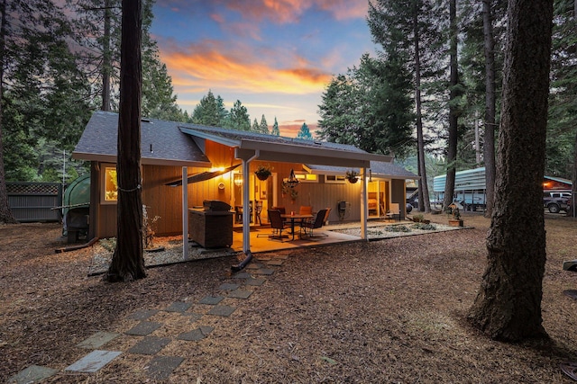 back house at dusk with a patio