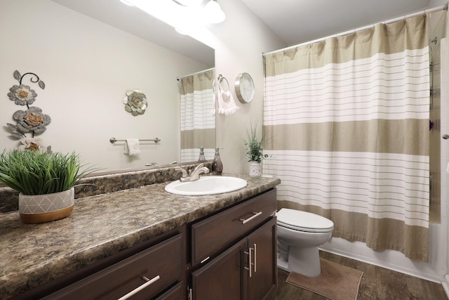 full bathroom featuring shower / tub combo, vanity, hardwood / wood-style flooring, and toilet