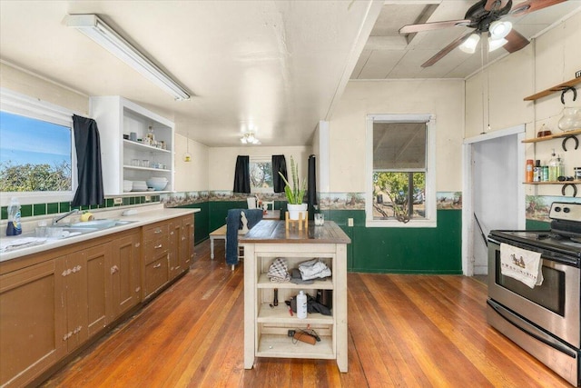 kitchen with stainless steel electric range oven, dark hardwood / wood-style flooring, and a healthy amount of sunlight