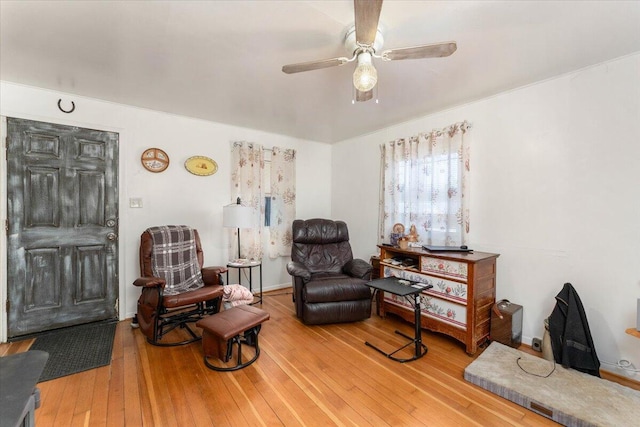 living area with wood-type flooring and ceiling fan