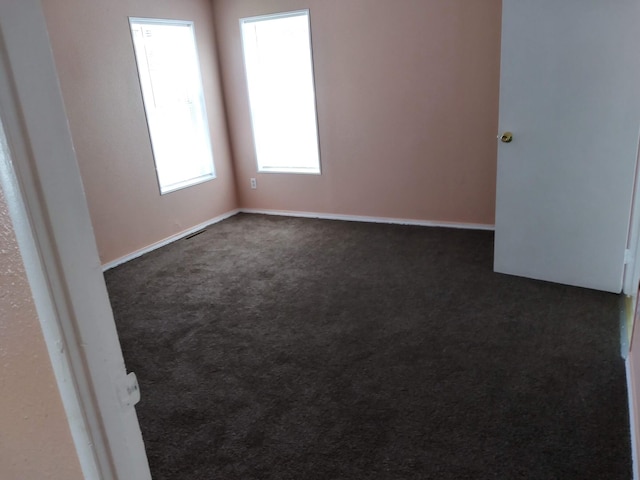 empty room with dark carpet