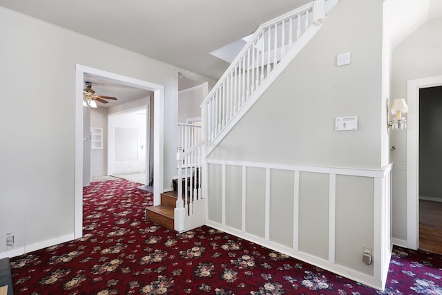 stairway featuring ceiling fan