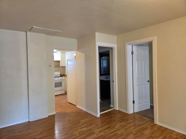 unfurnished room with a textured ceiling and hardwood / wood-style flooring