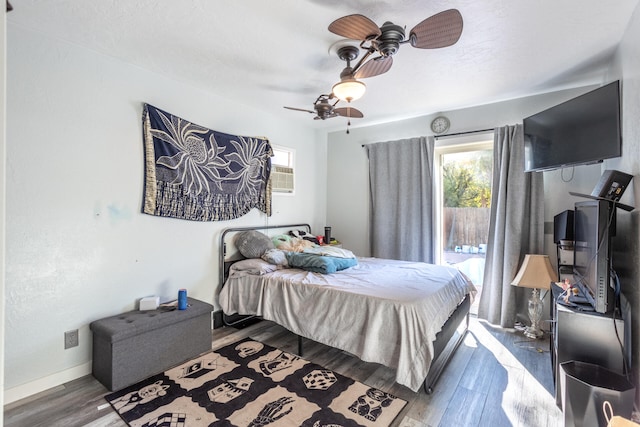 bedroom with hardwood / wood-style floors, ceiling fan, and access to outside