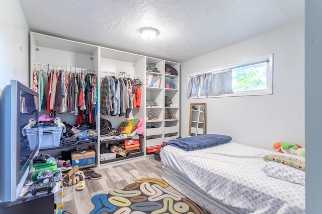 bedroom featuring hardwood / wood-style floors, a textured ceiling, and a closet