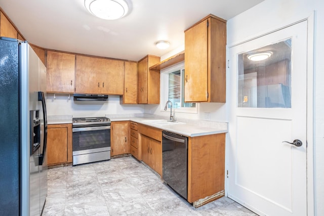 kitchen featuring a sink, light countertops, appliances with stainless steel finishes, exhaust hood, and brown cabinets