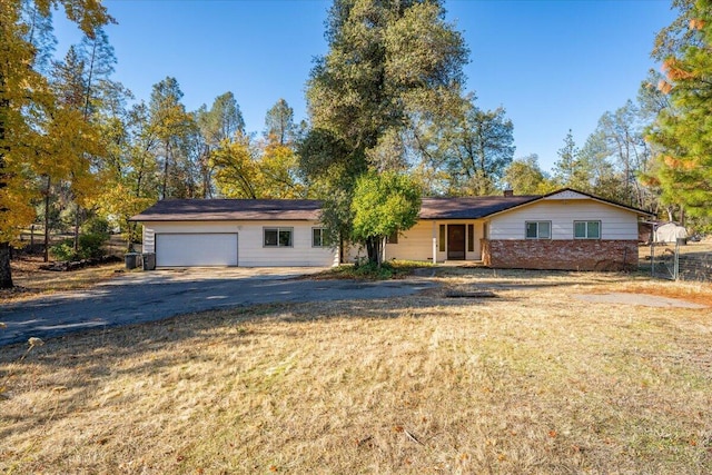 ranch-style home with a garage and a front lawn