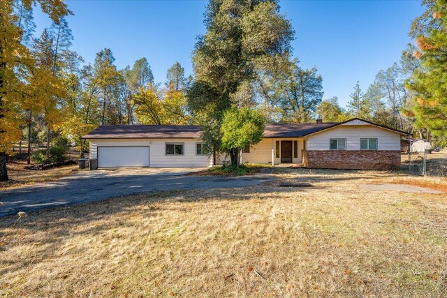 18142 Ranchera Rd, Shasta Lake, CA 96019 - ranch-style house featuring asphalt driveway, brick siding, and an attached garage