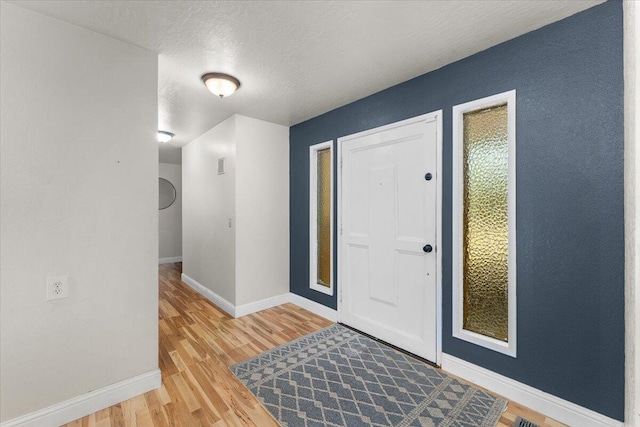 foyer with hardwood / wood-style flooring and a textured ceiling