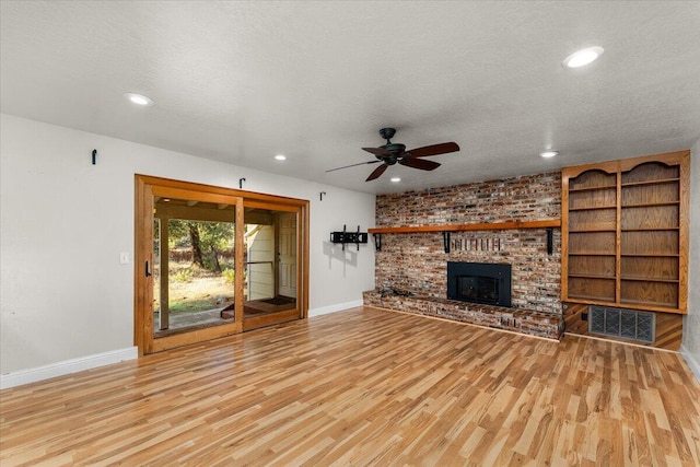 unfurnished living room featuring ceiling fan, light hardwood / wood-style floors, and a textured ceiling