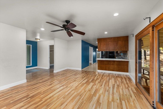 unfurnished living room with ceiling fan and light hardwood / wood-style floors