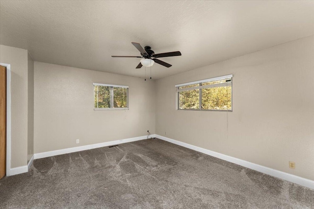 18142 Ranchera Rd, Shasta Lake, CA 96019 - spare room featuring a ceiling fan, dark carpet, and plenty of natural light