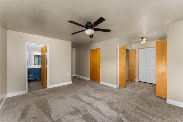 unfurnished bedroom with ensuite bath, ceiling fan, carpet, and a textured ceiling