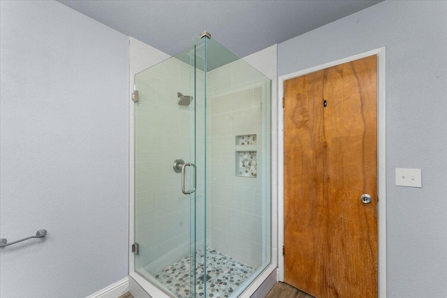 bathroom with hardwood / wood-style flooring and a shower with door