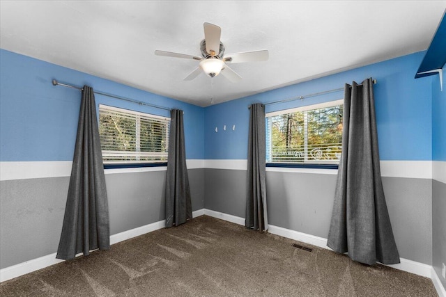 carpeted empty room featuring ceiling fan and a wealth of natural light