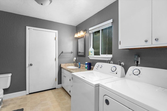 laundry area with a textured ceiling, separate washer and dryer, and sink