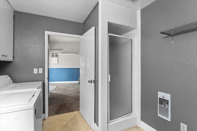 washroom featuring a textured ceiling, washer / clothes dryer, and heating unit