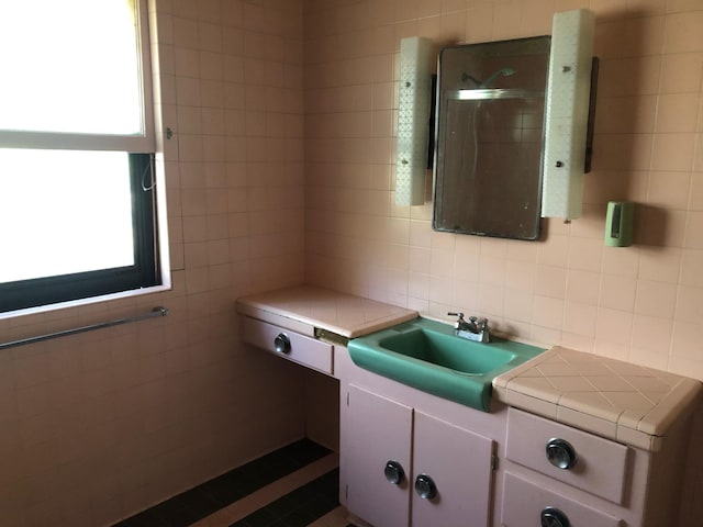 bathroom with decorative backsplash, tile walls, and vanity