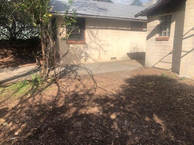 exterior space with a shingled roof, crawl space, and concrete block siding