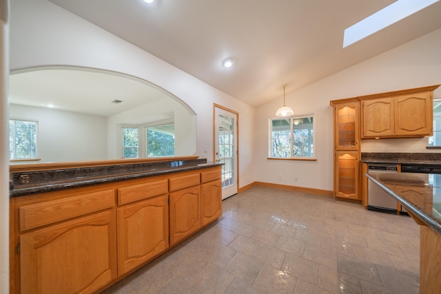 kitchen featuring vaulted ceiling with skylight, light tile patterned floors, hanging light fixtures, and stainless steel dishwasher