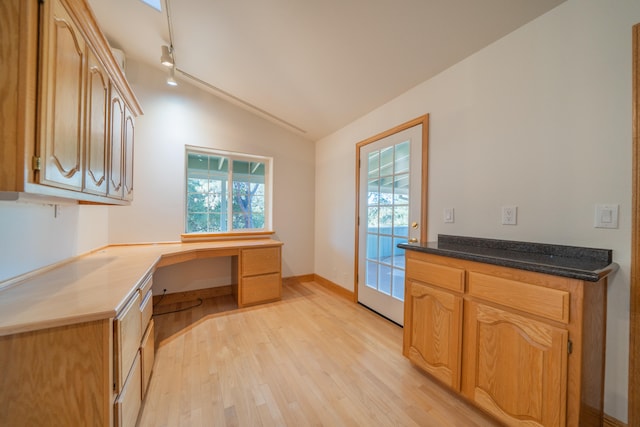 kitchen with light hardwood / wood-style floors, built in desk, and lofted ceiling