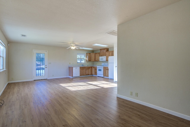 unfurnished living room with light hardwood / wood-style floors, ceiling fan, and sink