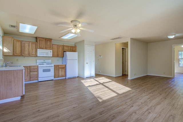 kitchen featuring ceiling fan, sink, white appliances, and light wood-type flooring