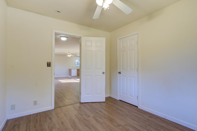 spare room with ceiling fan, light hardwood / wood-style floors, and vaulted ceiling