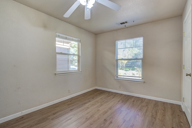 unfurnished room featuring light wood-type flooring, ceiling fan, and a healthy amount of sunlight