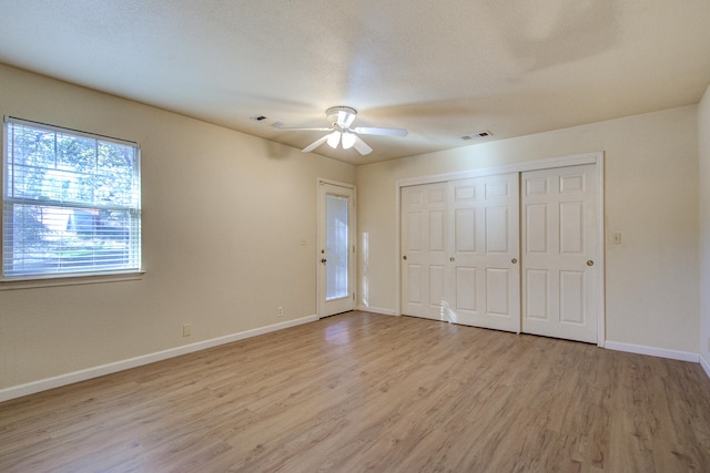 unfurnished bedroom featuring a textured ceiling, light wood-type flooring, and ceiling fan