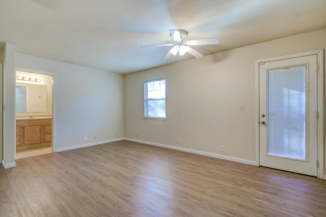 spare room featuring ceiling fan, sink, light hardwood / wood-style floors, and a textured ceiling