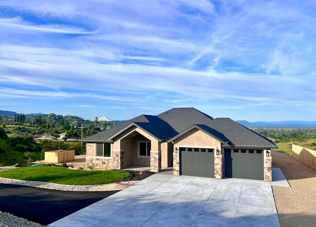 view of front of property featuring a mountain view, a front yard, and a garage