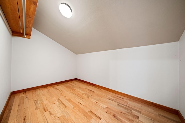 bonus room featuring light wood-type flooring and lofted ceiling