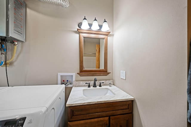 bathroom with washer and dryer, vanity, and water heater