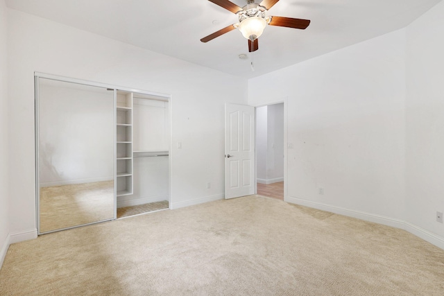 unfurnished bedroom with ceiling fan, a closet, and light carpet