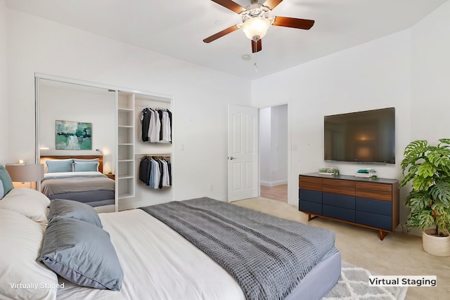 carpeted bedroom featuring ceiling fan and a closet