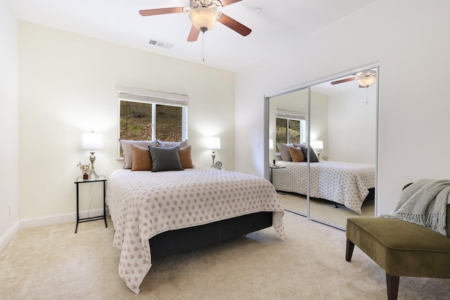 bedroom featuring ceiling fan, light colored carpet, and a closet