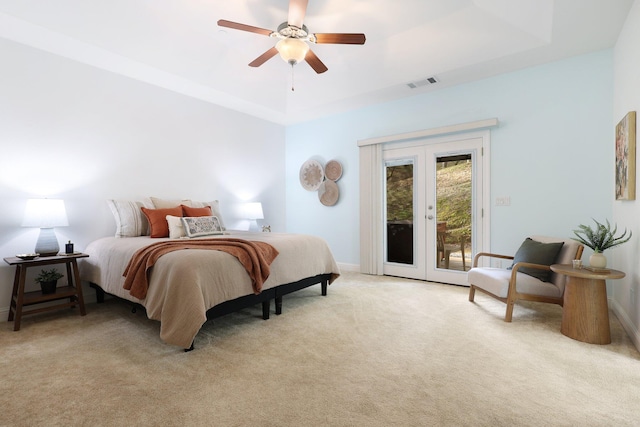 bedroom with light carpet, ceiling fan, a raised ceiling, access to outside, and french doors