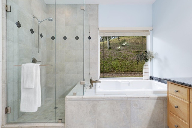 bathroom with plus walk in shower, plenty of natural light, and vanity