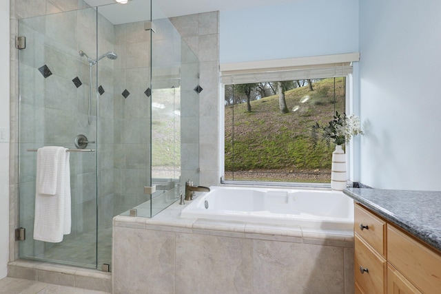 bathroom featuring tile patterned flooring, vanity, and shower with separate bathtub