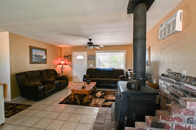 living room featuring a wood stove, ceiling fan, light tile patterned floors, and a wall mounted AC