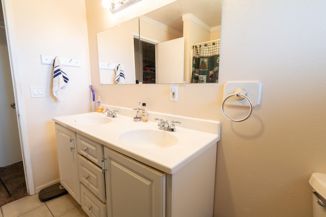 bathroom with toilet, vanity, tile patterned floors, and ornamental molding