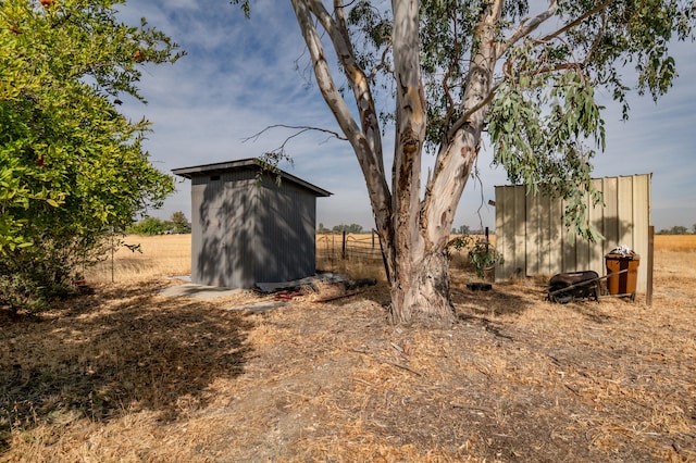 view of yard with a rural view and a storage shed