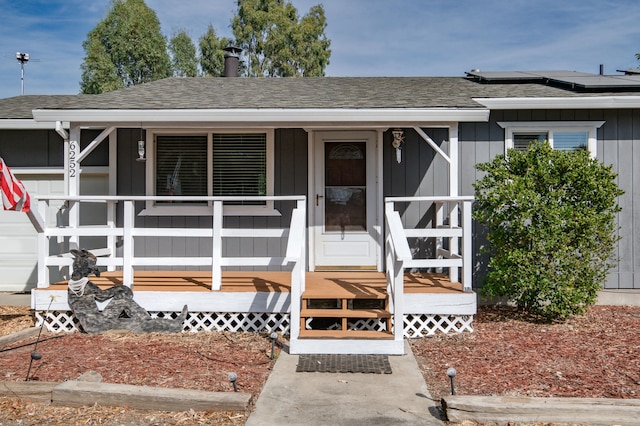 view of front facade featuring solar panels and a porch