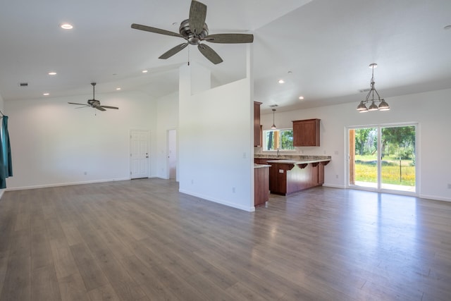 unfurnished living room with dark hardwood / wood-style flooring, high vaulted ceiling, ceiling fan, and sink