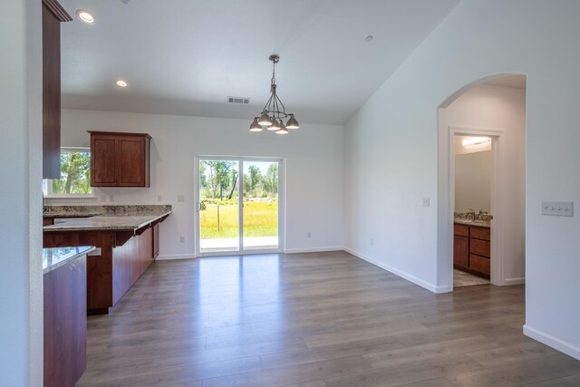 kitchen with pendant lighting, lofted ceiling, light hardwood / wood-style flooring, and a notable chandelier