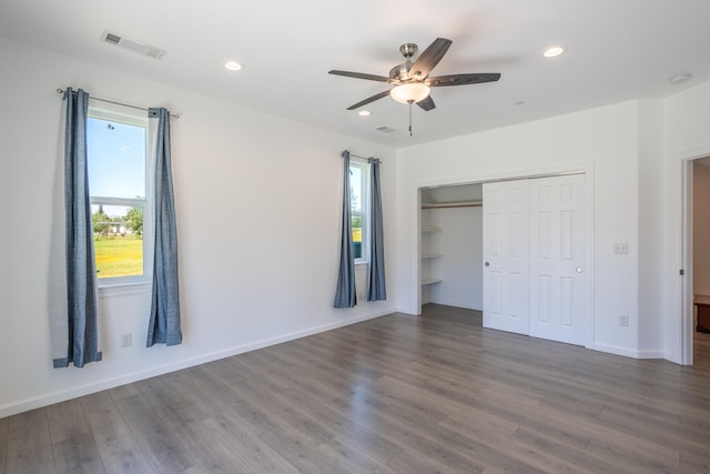 unfurnished bedroom with ceiling fan, wood-type flooring, and a closet