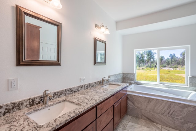 bathroom featuring vanity and tiled tub