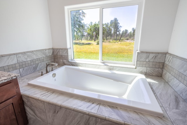 bathroom with vanity and tiled bath